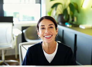 Friendly dental team member sitting behind front desk