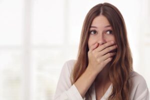 Embarrassed woman using her hand to hide her smile